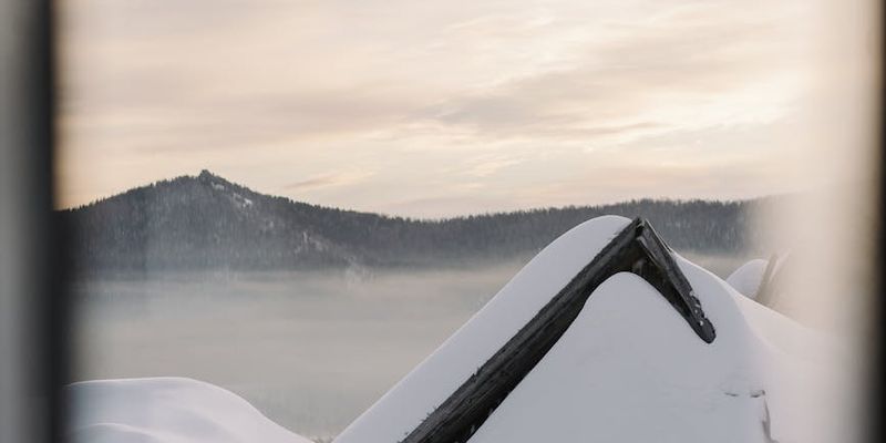 Silhouette of a person meditating during sunrise over mountains.
